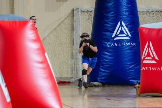 Игрок LASERWAR в движении за синим укрытием.